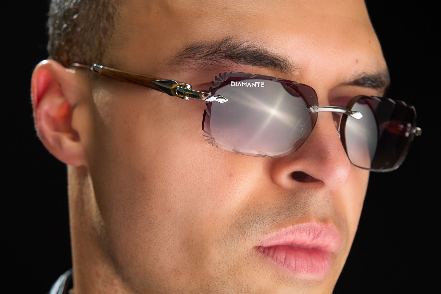 Close-up of hand-faceted diamond cut lens edges on a rimless Diamante frame